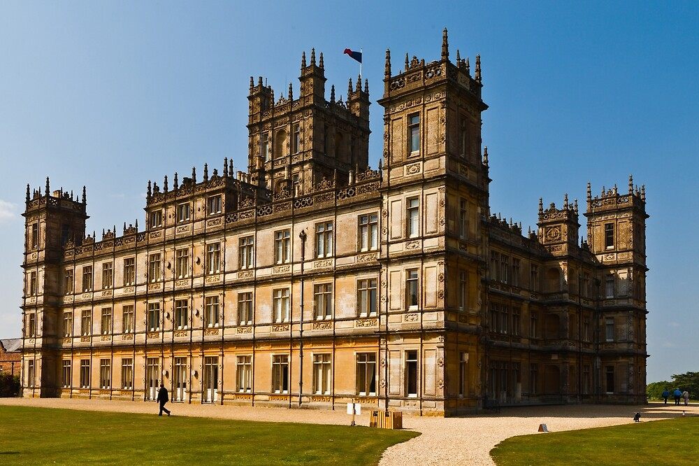 The grand façade of Highclere Castle under a clear sky