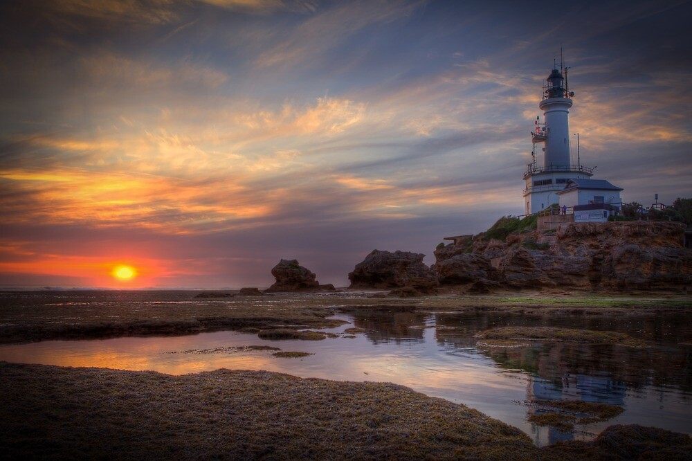 Point Lonsdale Lighthouse at sunset above tidal rock pools